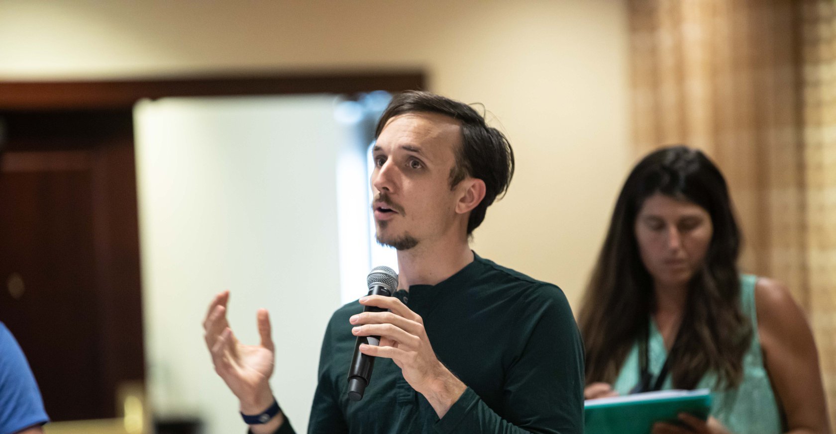 Kyle Gray speaking on stage with a microphone
